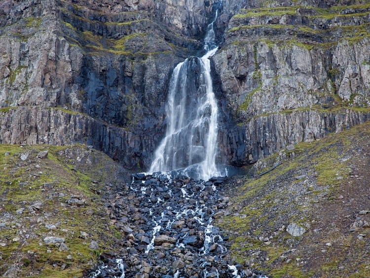 Dj&uacute;pav&iacute;k, Island - Wasserfall st&uuml;rzt &uuml;ber Felswand ins Tal