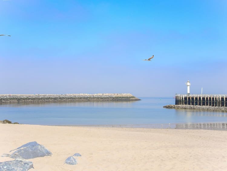 Ostende, Belgien &ndash; Sandstrand mit kleinem wei&szlig;en Leuchtturm am Pier