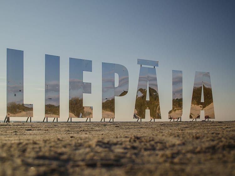 Liepāja Lettland &ndash; gespiegelt gl&auml;nzende Buchstaben am Sandstrand