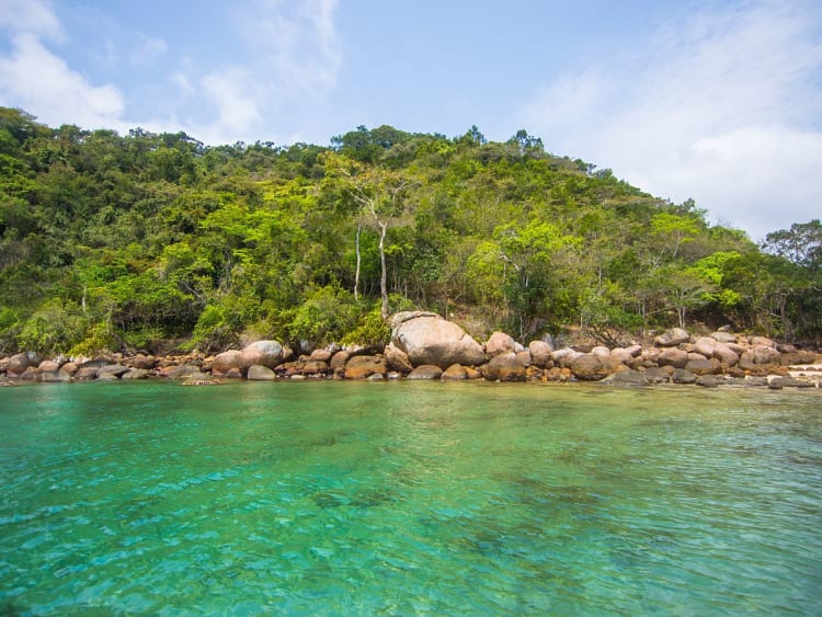 Angra dos Reis, Brasilien &ndash; Dichte gr&uuml;ne Vegetation an einer felsigen K&uuml;ste mit t&uuml;rkisfarbenem Wasser