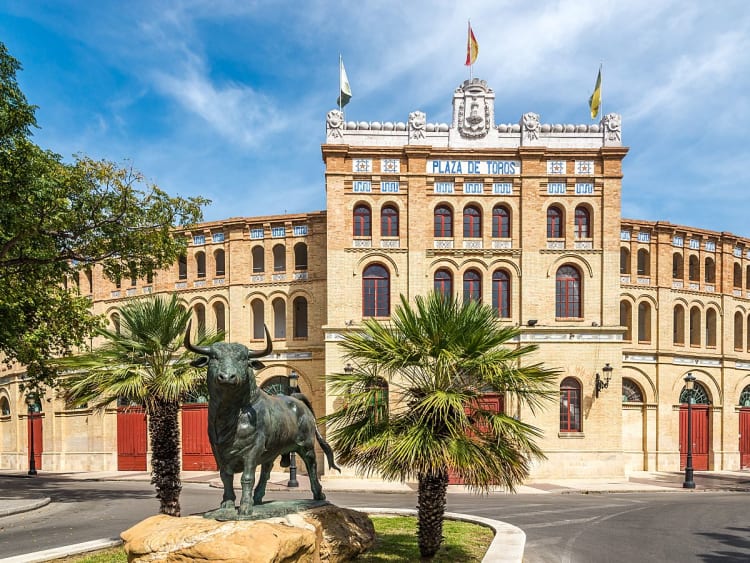 El Puerto de Santa Mar&iacute;a, Spanien &ndash; Fassade der Plaza de Toros mit Palmen und blauem Himmel