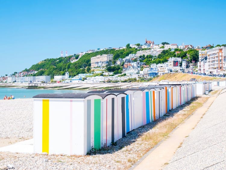 Le Havre, Frankreich &ndash; Bunte Strandh&uuml;tten am Kieselstrand mit Blick auf die Stadt
