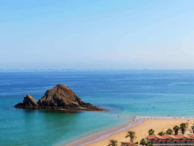 Fujairah, VAE &ndash; Strand mit Blick auf Snoopy Island im klaren t&uuml;rkisfarbenen Wasser