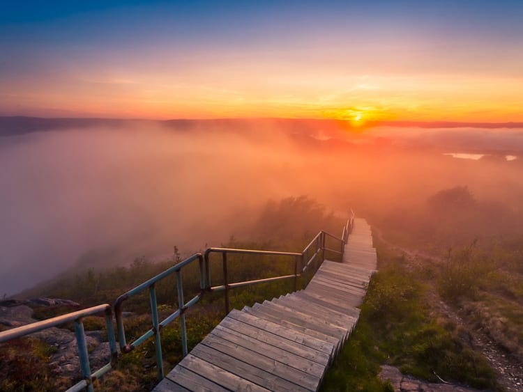 Saint John, Kanada &ndash; Holztreppe f&uuml;hrt in den Nebel mit Sonnenuntergang am Horizont