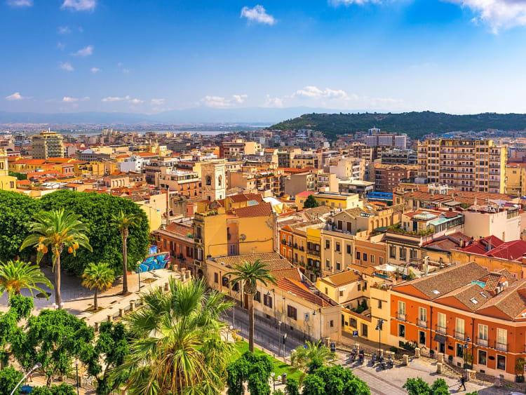 Cagliari, Italien &ndash; Weitblick &uuml;ber die D&auml;cher der Altstadt mit Palmen und blauem Himmel