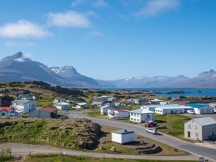 Dj&uacute;pivogur, Island &ndash; K&uuml;stendorf mit kleinen H&auml;usern, Bergen und Meer im Hintergrund