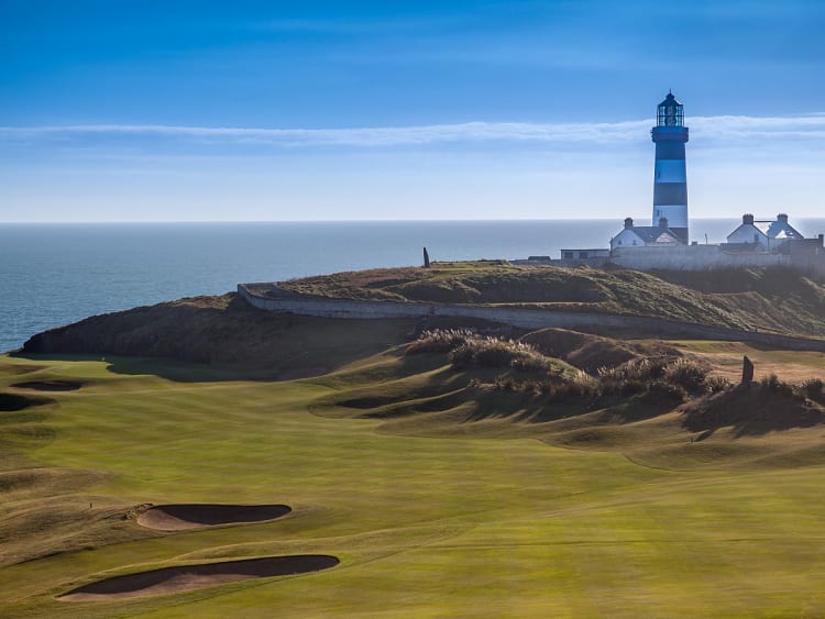 Cork, Irland &ndash; K&uuml;stenlandschaft mit schwarz-wei&szlig; gestreiftem Leuchtturm und weitem Meerblick