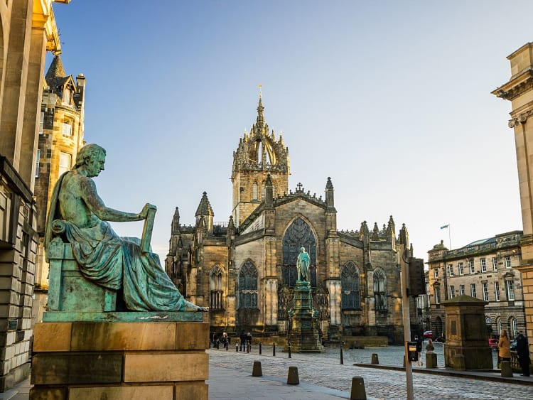 Edinburgh, Schottland &ndash; St. Giles&rsquo; Cathedral auf der Royal Mile mit Statue im Vordergrund