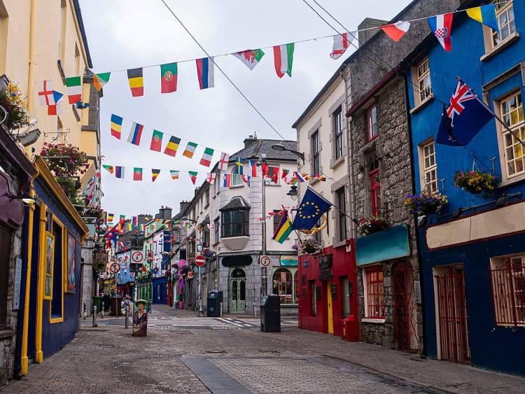 Galway, Irland &ndash; Bunte Altstadtgasse mit internationalen Flaggen und farbenfrohen Hausfassaden
