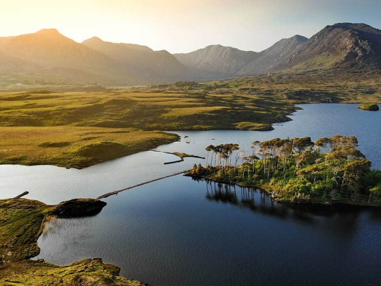 Galway, Irland &ndash; Luftaufnahme des Connemara Nationalparks mit See, Inseln und Bergkulisse im Abendlicht