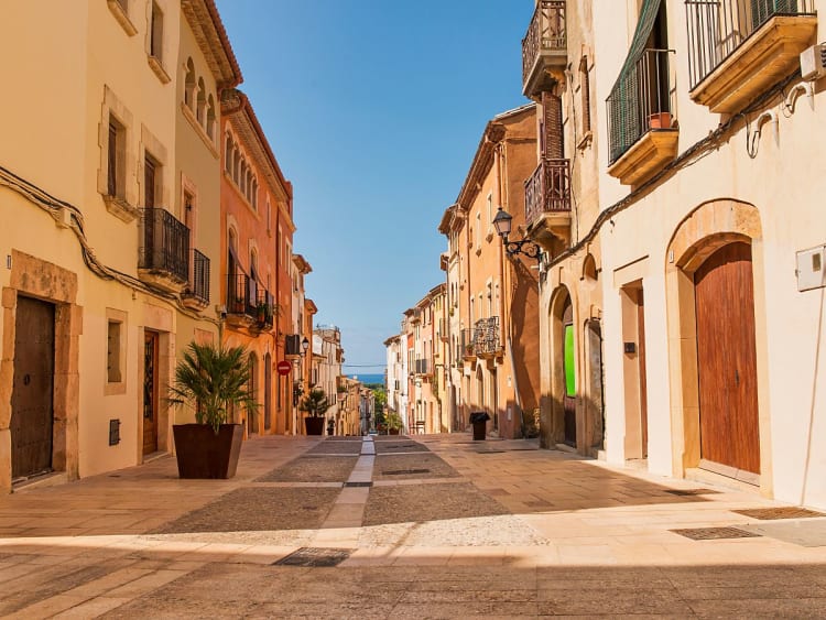 Tarragona, Spanien &ndash; Sonnige Altstadtstra&szlig;e mit historischen Geb&auml;uden und Blick Richtung Meer
