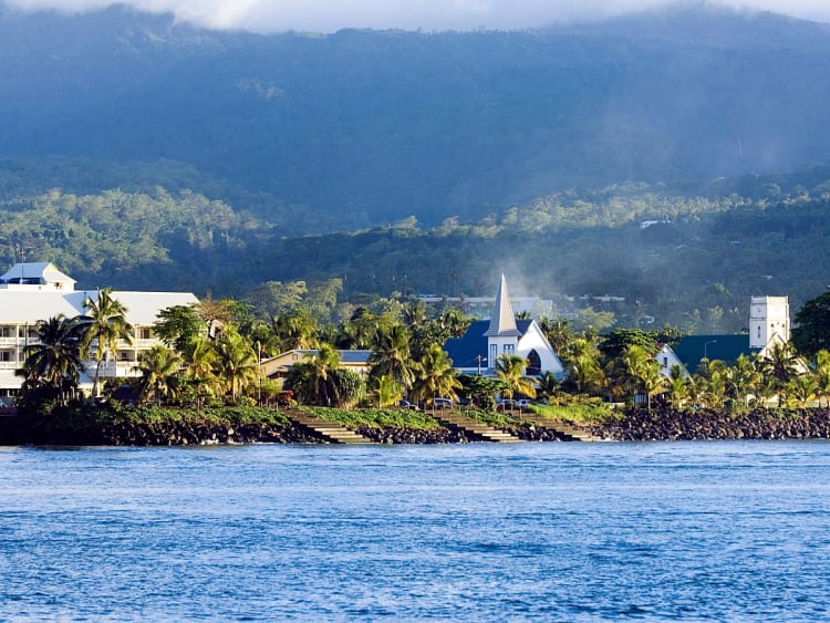 Apia, Upolu, Samoa &ndash; Blick auf die K&uuml;ste mit H&auml;usern, Kirchen und gr&uuml;nen Bergen im Hintergrund