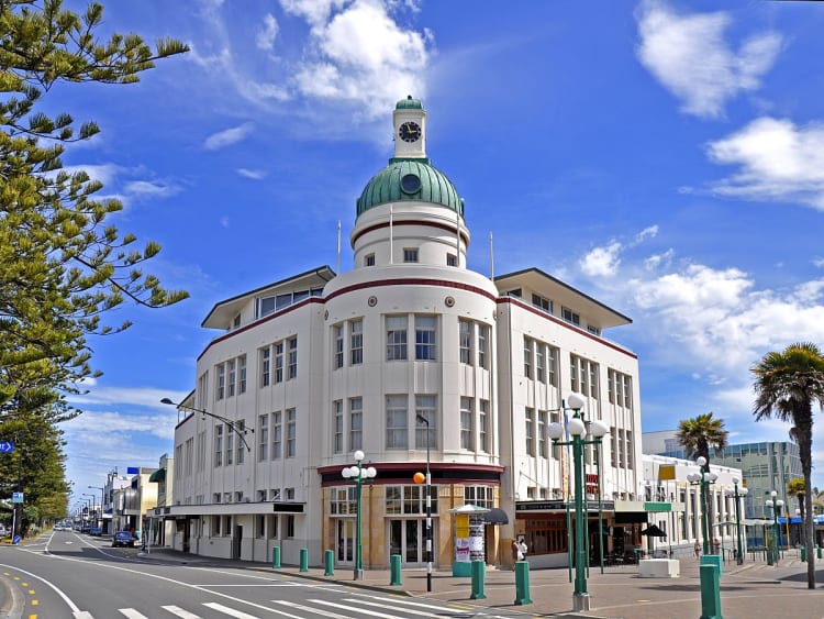 Napier, Neuseeland &ndash; Architektur im Art-d&eacute;co-Stil mit Uhrturm und Palmen unter blauem Himmel