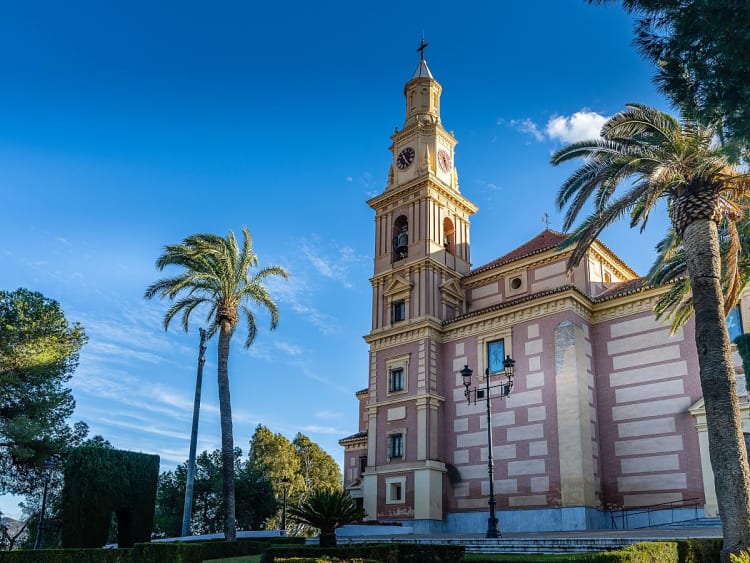 Motril, Spanien &ndash; barocke Fassade mit Uhrturm ragt &uuml;ber Palmen und G&auml;rten
