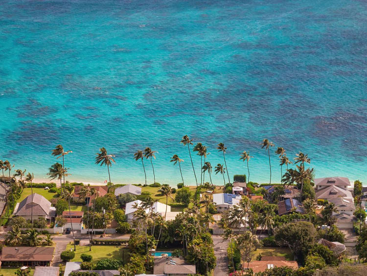 Kailua-Kona, USA &ndash; H&auml;userreihe an Palmenstrand vor t&uuml;rkisfarbenem Wasser