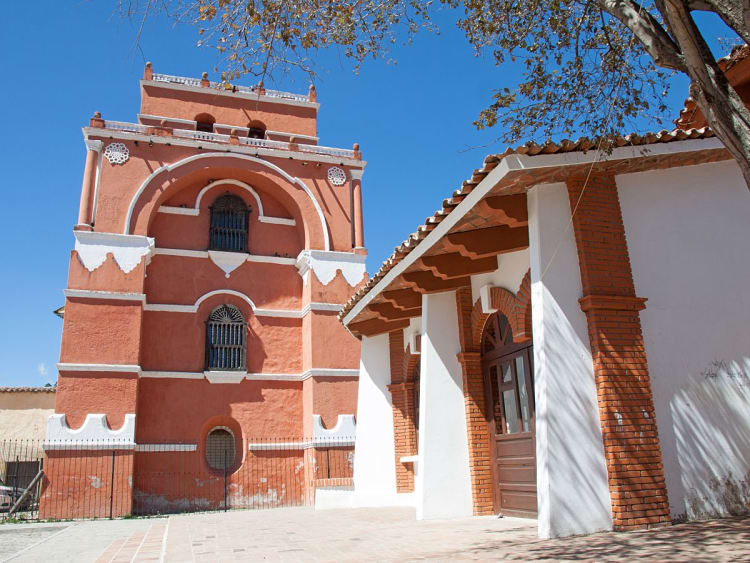 Puerto Chiapas, Mexiko &ndash; Roter Kirchturm mit wei&szlig;en Zierb&auml;ndern unter blauem Himmel