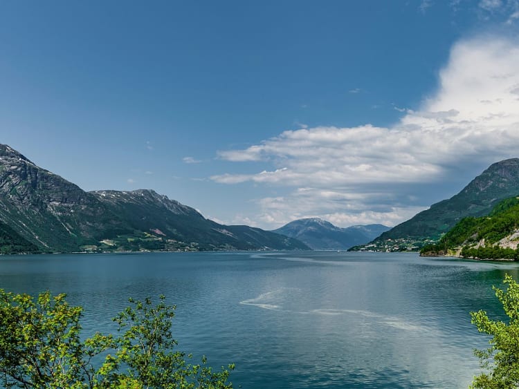 Hardangerfjord, Norwegen &ndash; Fjord&ouml;ffnung mit gr&uuml;nen H&auml;ngen und schneebedeckten H&ouml;hen