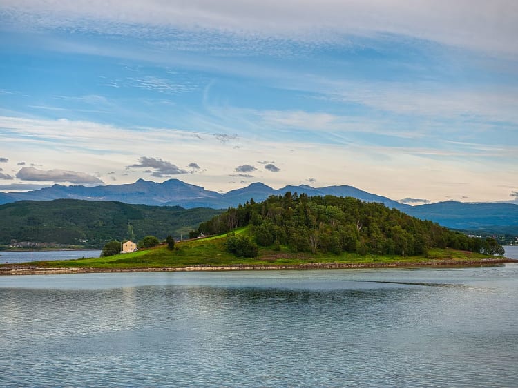 Harstad, Norwegen &ndash; Kleine bewaldete Insel liegt ruhig im klaren Fjordwasser