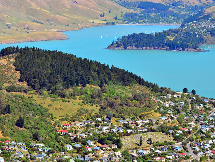 Christchurch, Neuseeland &ndash; Siedlung am gr&uuml;nen Hang &uuml;ber t&uuml;rkisfarbener Bucht
