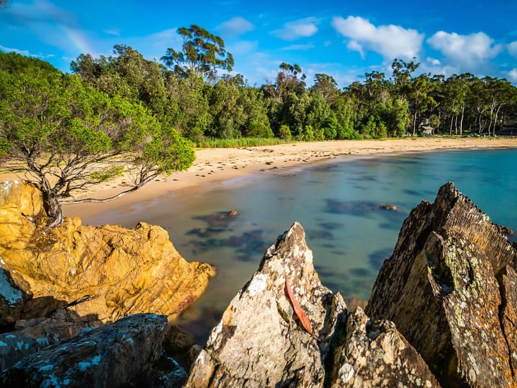 Eden, Australien &ndash; abgeschiedene Bucht mit goldfarbenem Sand und schroffen Felsen
