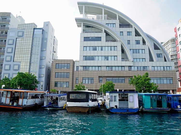 Mal&eacute;, Malediven &ndash; Boote liegen vor moderner Uferarchitektur im t&uuml;rkisblauen Wasser