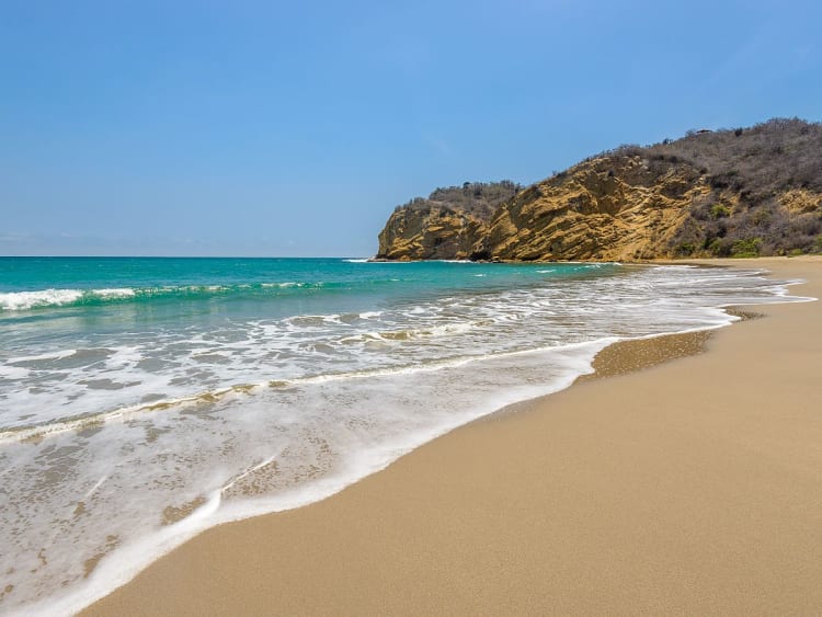 Manta, Ecuador &ndash; goldener Sandstrand mit t&uuml;rkisfarbenem Wasser und felsiger Landzunge