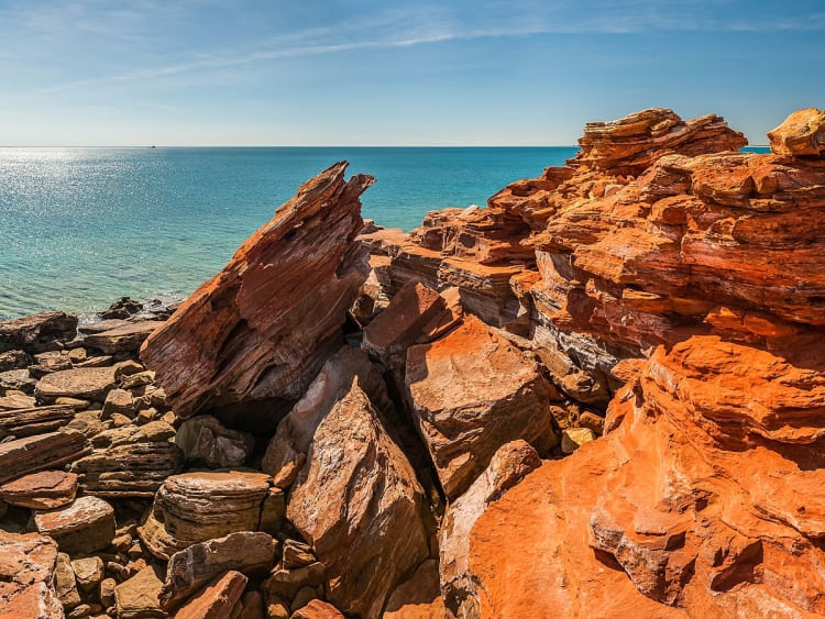 Broome, Australien &ndash; zerkl&uuml;ftete rote Felsen am ruhigen, glitzernden Ozean