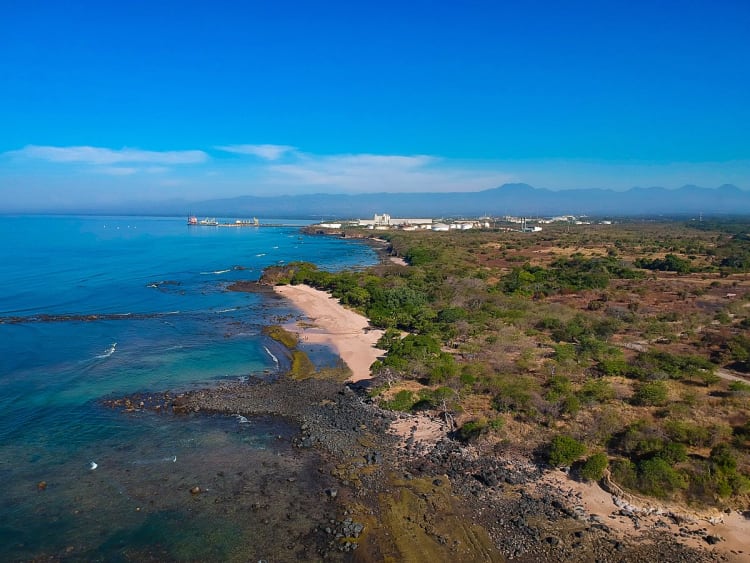 Acajutla, El Salvador &ndash; langer Strand mit Blick auf Hafenanlagen und Berge