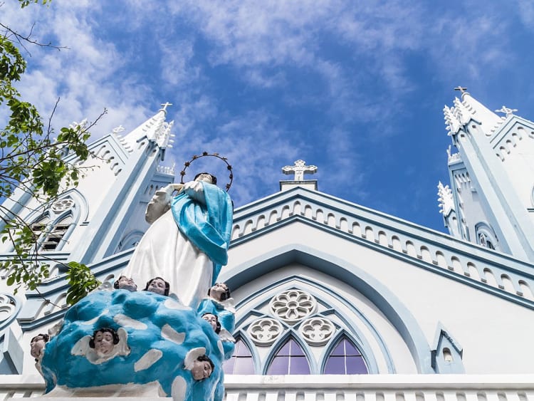 Puerto Princesa, Philippinen &ndash; Kirche mit T&uuml;rmen und Statue im Vordergrund