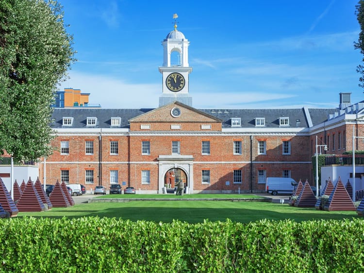 Portsmouth, England &ndash; Historisches Hafengeb&auml;ude mit Uhrturm und gepflegtem Rasen