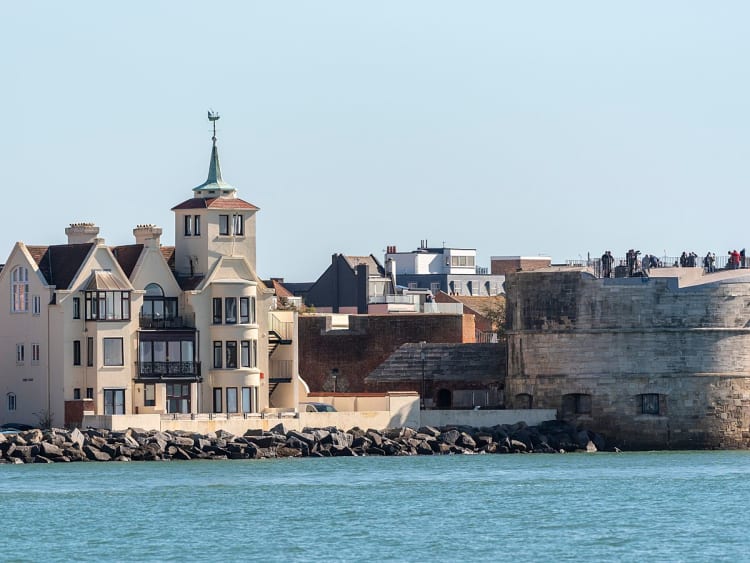 Portsmouth, England &ndash; K&uuml;stenblick mit Festungsmauer und H&auml;usern am Wasser