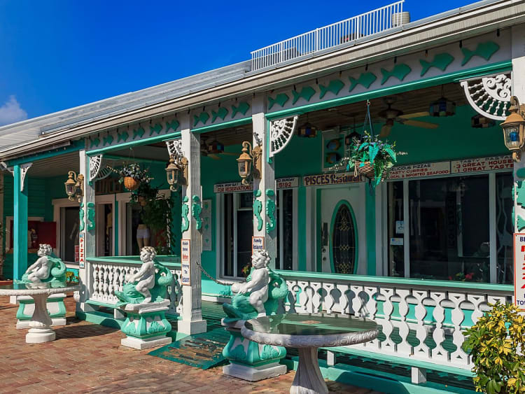 Grand Bahama, Bahamas &ndash; T&uuml;rkisfarbenes Restaurant mit Veranda und Dekorstatuen