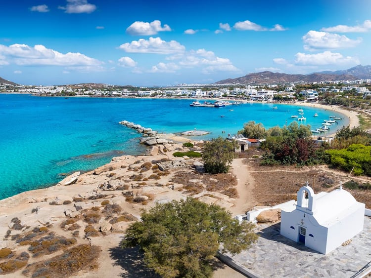 Agia Anna (Naxos), Griechenland &ndash; K&uuml;stenort mit t&uuml;rkisblauer Bucht, Sandstrand und kleiner wei&szlig;er Kapelle am Meer.