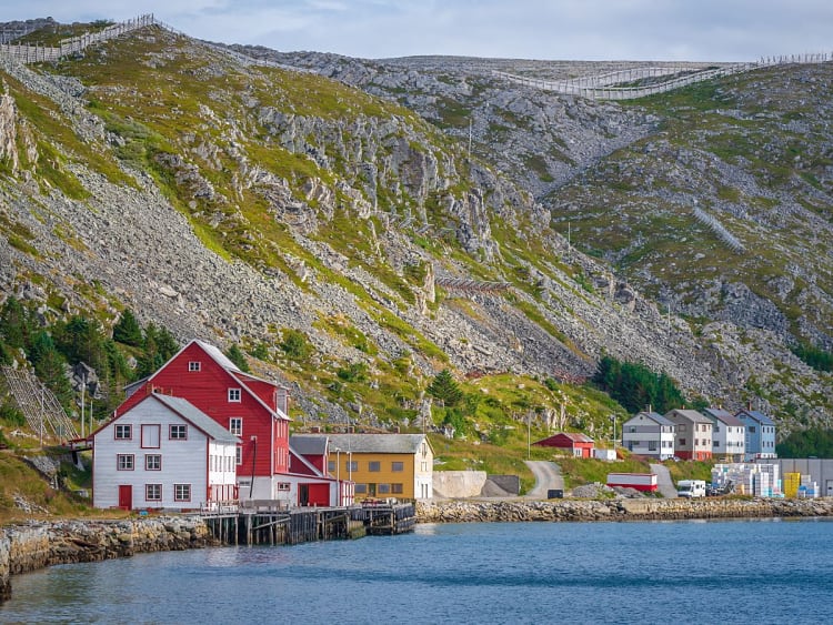 Kj&oslash;llefjord, Norwegen - Rote H&auml;user am Wasser vor steiler Felslandschaft