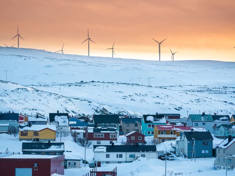 Kj&oslash;llefjord, Norwegen - Verschneiter Ort mit bunten H&auml;usern und Windr&auml;dern am Horizont