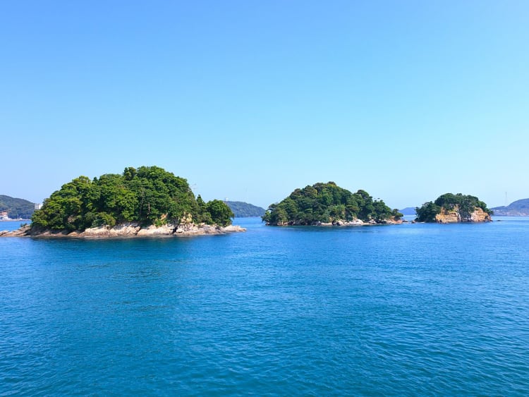 Toba, Japan - Kleine gr&uuml;ne Inseln liegen im ruhigen blauen Meer
