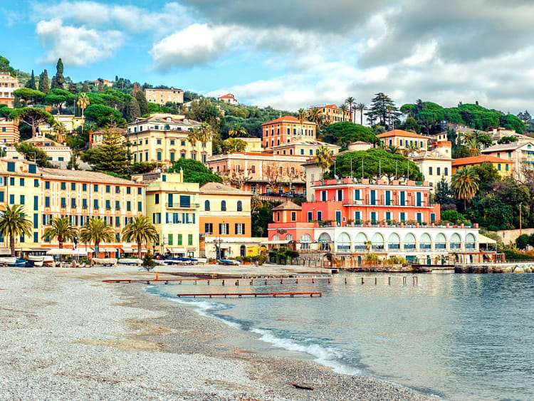 Santa Margherita, Italien - Bunte H&auml;user entlang der K&uuml;ste mit Palmen und sanftem Wellengang am Strand