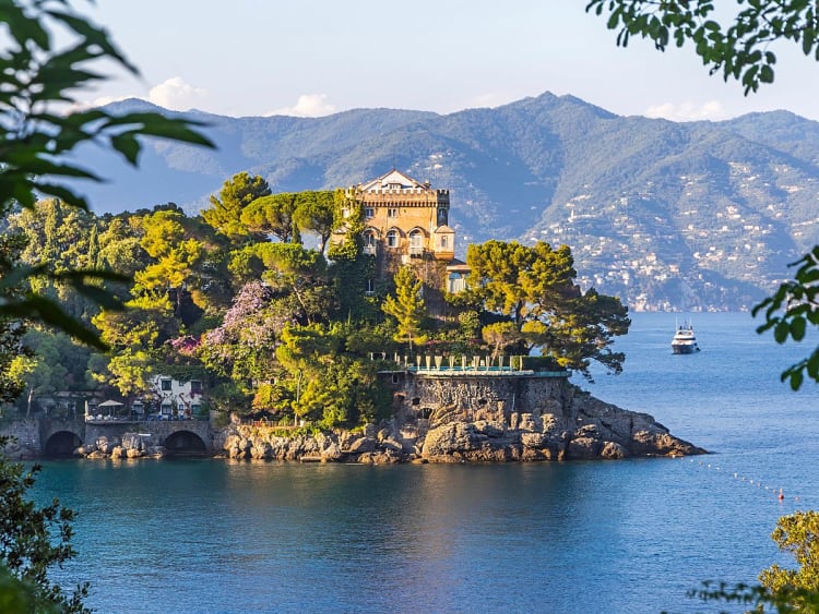 Santa Margherita, Italien - Elegantes Anwesen auf einer bewaldeten Halbinsel mit Blick auf das Wasser und Berge im Hintergrund