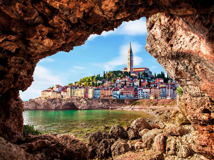 Piran, Slowenien - K&uuml;stenstadt mit bunten H&auml;usern und Kirche, eingerahmt von einer nat&uuml;rlichen Felsformation