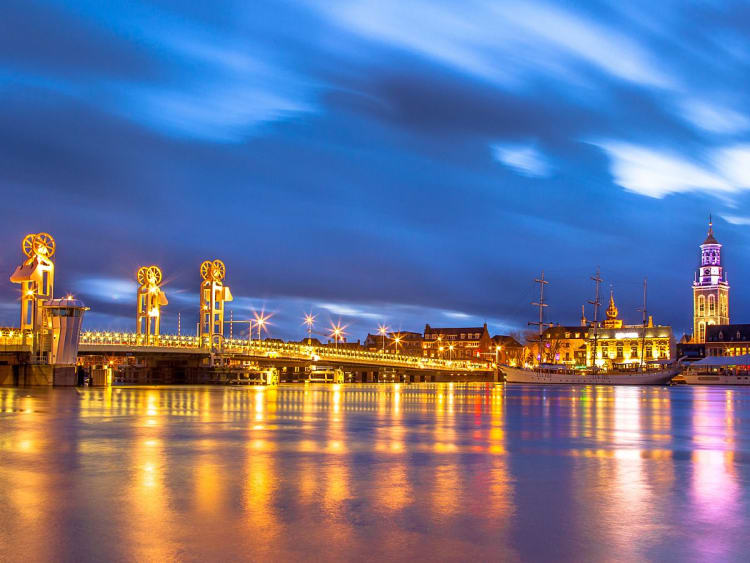 Kampen, Niederlande &ndash; Beleuchtete Br&uuml;cke und Kirche spiegeln im Fluss bei Nacht