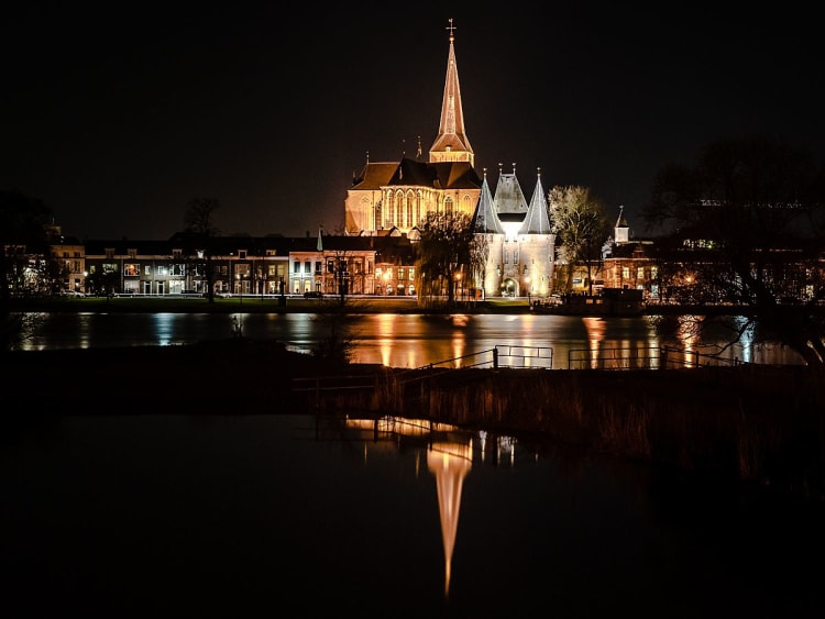 Kampen, Niederlande &ndash; Beleuchtete Kirche spiegelt sich nachts im ruhigen Fluss