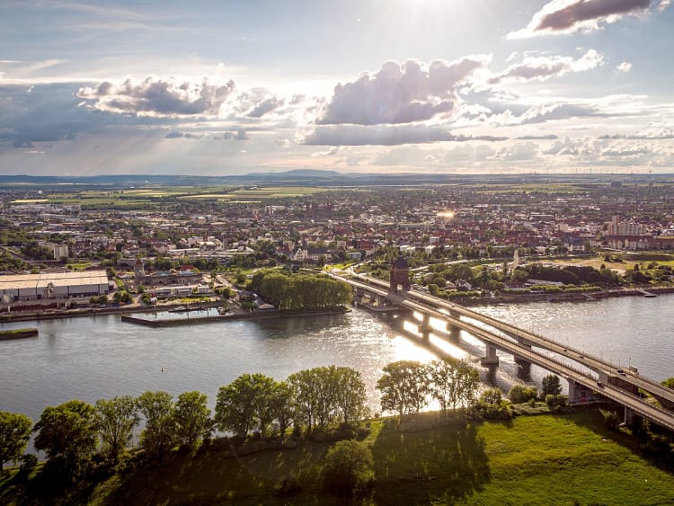 Worms, Deutschland - Flusslandschaft mit Br&uuml;cke und Stadt im warmen Sonnenlicht