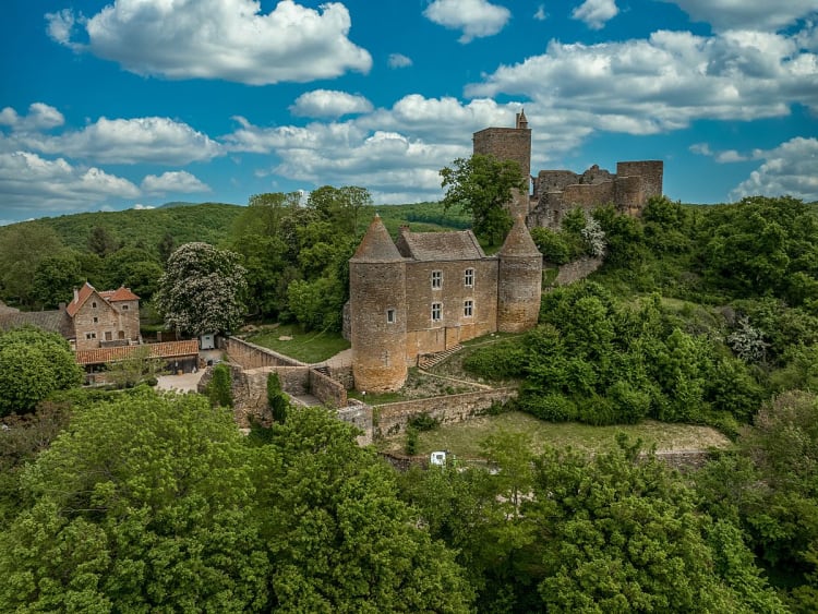 Tournus (Frankreich) - Burganlage mit T&uuml;rmen auf gr&uuml;nem H&uuml;gel in l&auml;ndlicher Landschaft
