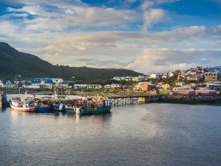 Puerto Chacabuco in Chile &ndash; Hafen mit Booten und Siedlung vor gr&uuml;nen H&uuml;geln