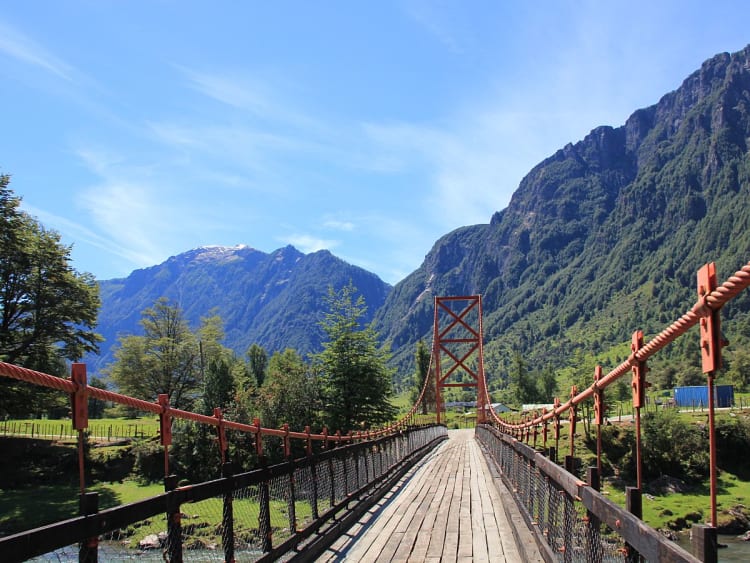 Puerto Chacabuco, Chile &ndash; Schmale Br&uuml;cke &uuml;ber Fluss zwischen Bergen und Wiesen