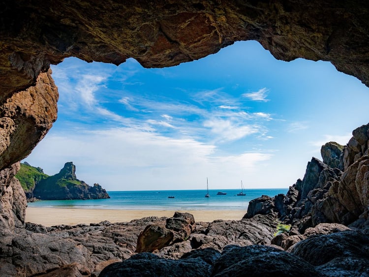 Guernsey, Ilhas do Canal &ndash; Vista de uma gruta rochosa para uma ba&iacute;a de areia