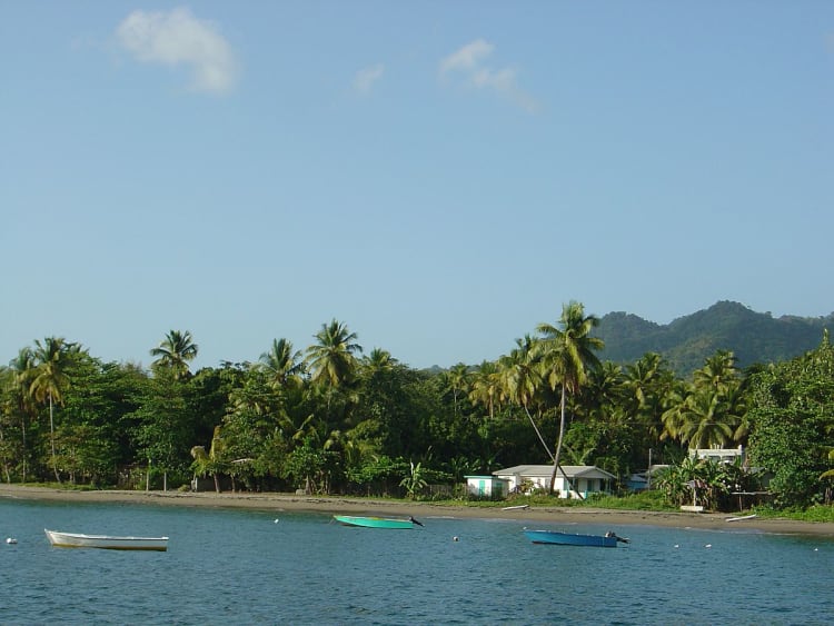 Portsmouth, Dominica &ndash; Costa tropical con palmeras, barcos y monta&ntilde;as verdes