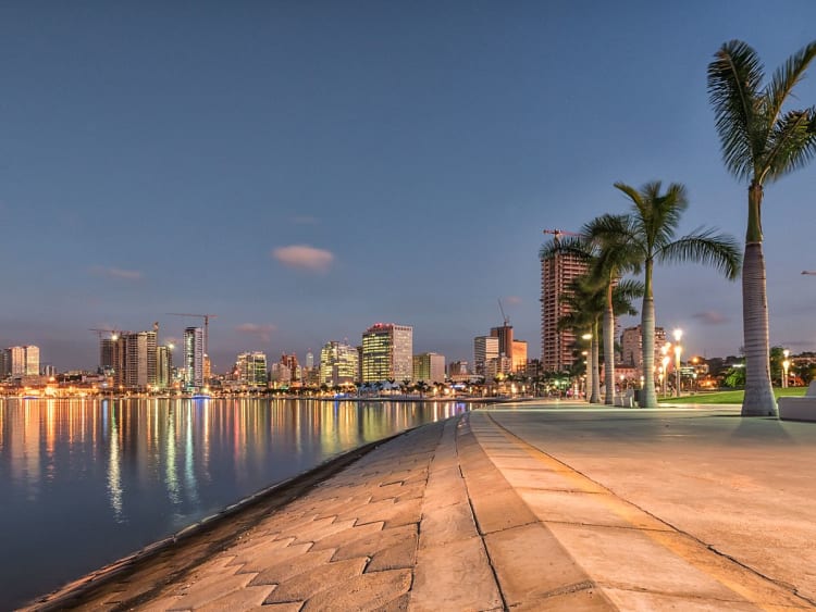 Luanda, Angola &ndash; Paseo mar&iacute;timo con palmeras y horizonte urbano iluminado