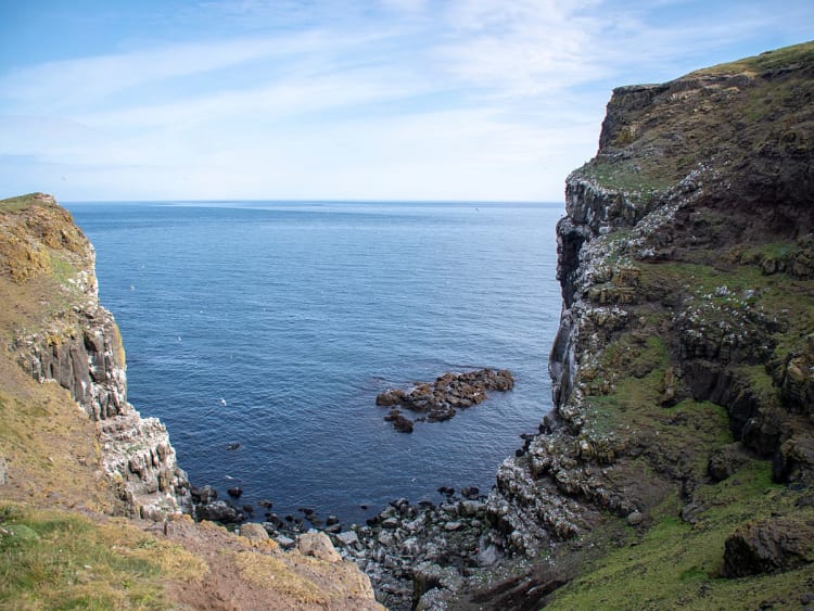 Gr&iacute;msey, Island &ndash; Felsige Schlucht zwischen Klippen und blauem Meer