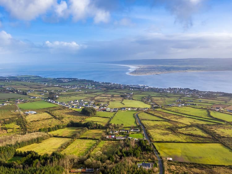 Greencastle, Irlanda &ndash; Vista panor&aacute;mica de verdes campos y una amplia bah&iacute;a